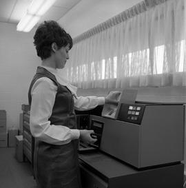 Promotional photograph of a computer operator at a punch card reader