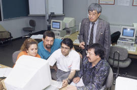 Photograph of an instructor working with students in the computer lab