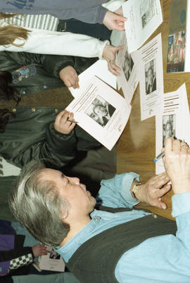 Photograph of Wayson Choy signing posters
