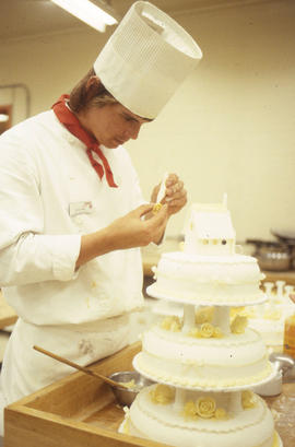 Photograph of a Hospitality student decorating a cake