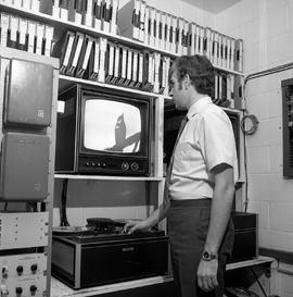 Photograph of a Grant Goodick in the IMC playing back a video tape