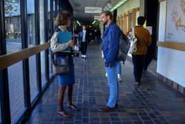 Photograph of two students talking in the hallway