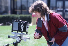 Photograph of a student using a large format camera in front of D building