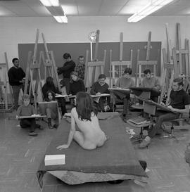 Photograph of students sketching a female nude model