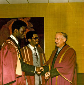 Photograph of Gordon Wragg congratulating two students from St. Vincent at Convocation
