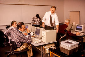 Photograph of Jim Hardy in a computer lab with students