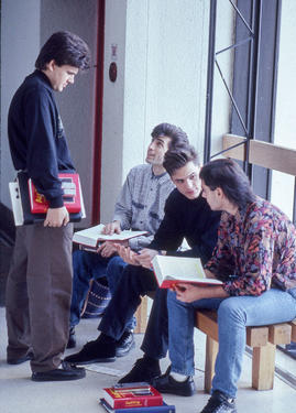 Photograph of students chatting whilst seated at a window