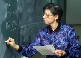 Photograph of Faculty member Barbara McGregor writing on the chalkboard during a class