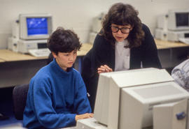 Photograph of a professor helping a student on the computer