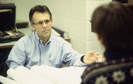 Photograph of a technology faculty member conversing with a student
