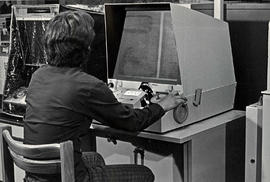 Photograph of a Student Using a Microfiche Reader in the Library