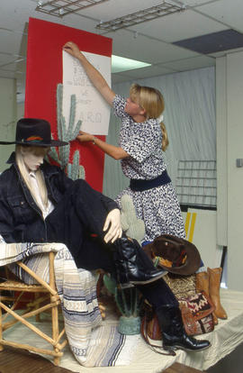 Photograph of a Retail Co-op program student creating a window display