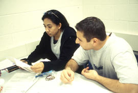 Photograph of students reviewing an assignment in a COBOL programming class