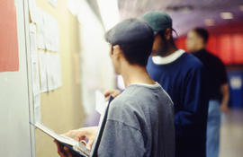A photograph of students looking at a job board