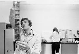 Photograph of a Photography Student Looking at a Strip of Negatives
