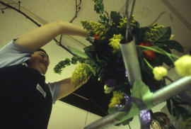 A photograph of a Retail Floriculture student working on a floral arrangement