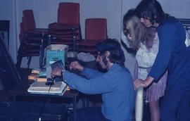 People viewing 8mm Film Strips : [photograph]