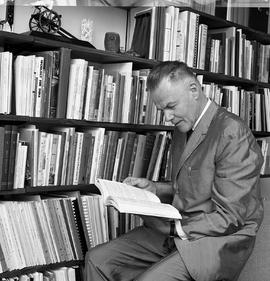 Photograph of J.Roby Kidd reading a book