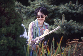 Photograph of a student working at sketching in the Arboretum