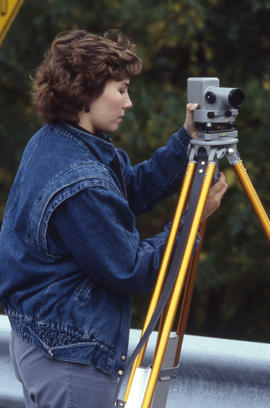 Photograph of a student setting up surveying equipment