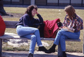 Photograph of Two Girls Talking on a Bench