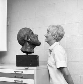Photograph of Denise McNeil facing a Gary Noseworthy sculpture