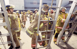 A photograph of Firefighting students lined up in front of ladders