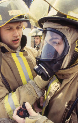 A photograph of two Firefighting students in head gear