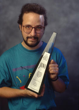 Photograph of Brian Dickenson holding his JUNO award that he won
