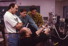 Photograph of a faculty member instructing students in the Electronics lab