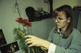 A photograph of a Retail Floriculture student building a floral arrangement