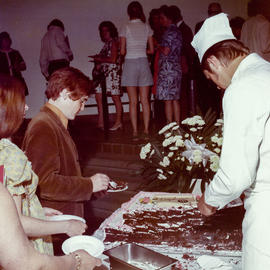Photograph of a chef cutting slices of cake for guests at the convocation reception