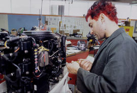 Photograph of a student working on a small engine