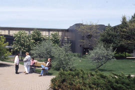 Photograph of students sitting on a bench at Lakeshore