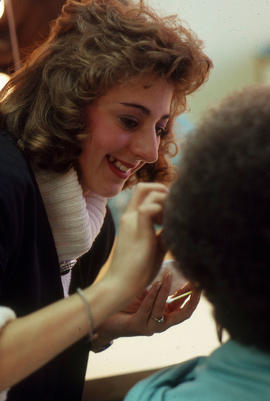 Photograph of student applying makeup to client in the makeup studio