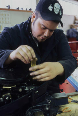 Photograph of student working on a small engine