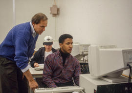 Photograph of George Byrnes assisting a student in class