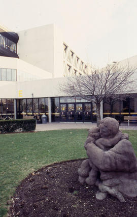 Photograph of mother and child sculpture on the lawn in front of the entrance to "E" bu...