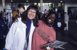 Photograph of two persons posing for the camera in the concourse