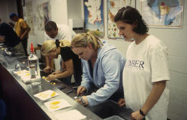 A photograph of students at a steel counter in the Bartending lab