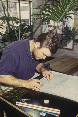 A photograph of a student drawing plans for a garden design