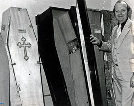 Photograph of Paul Faris Standing Next to Coffins He Aquired for His Class