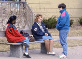 Photograph of students sitting on a bench outside