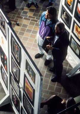Photograph of two people discussing a photo display