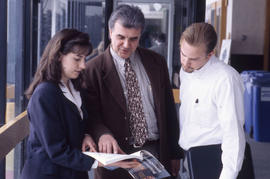 Photograph of an instructor and students in the hallway