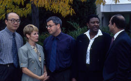 Photograph of staff standing under a tree