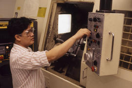 Photograph of a Student Adjusting Controls on a Machine