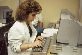 Photograph of a Journalism student typing a newspaper article into a computer