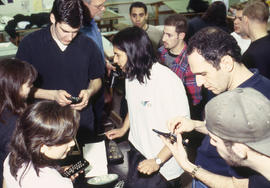 A photograph of Industrial Design students examining each other's designs