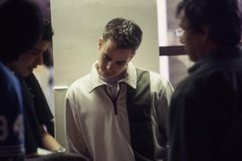 A photograph of students huddled in a hallway